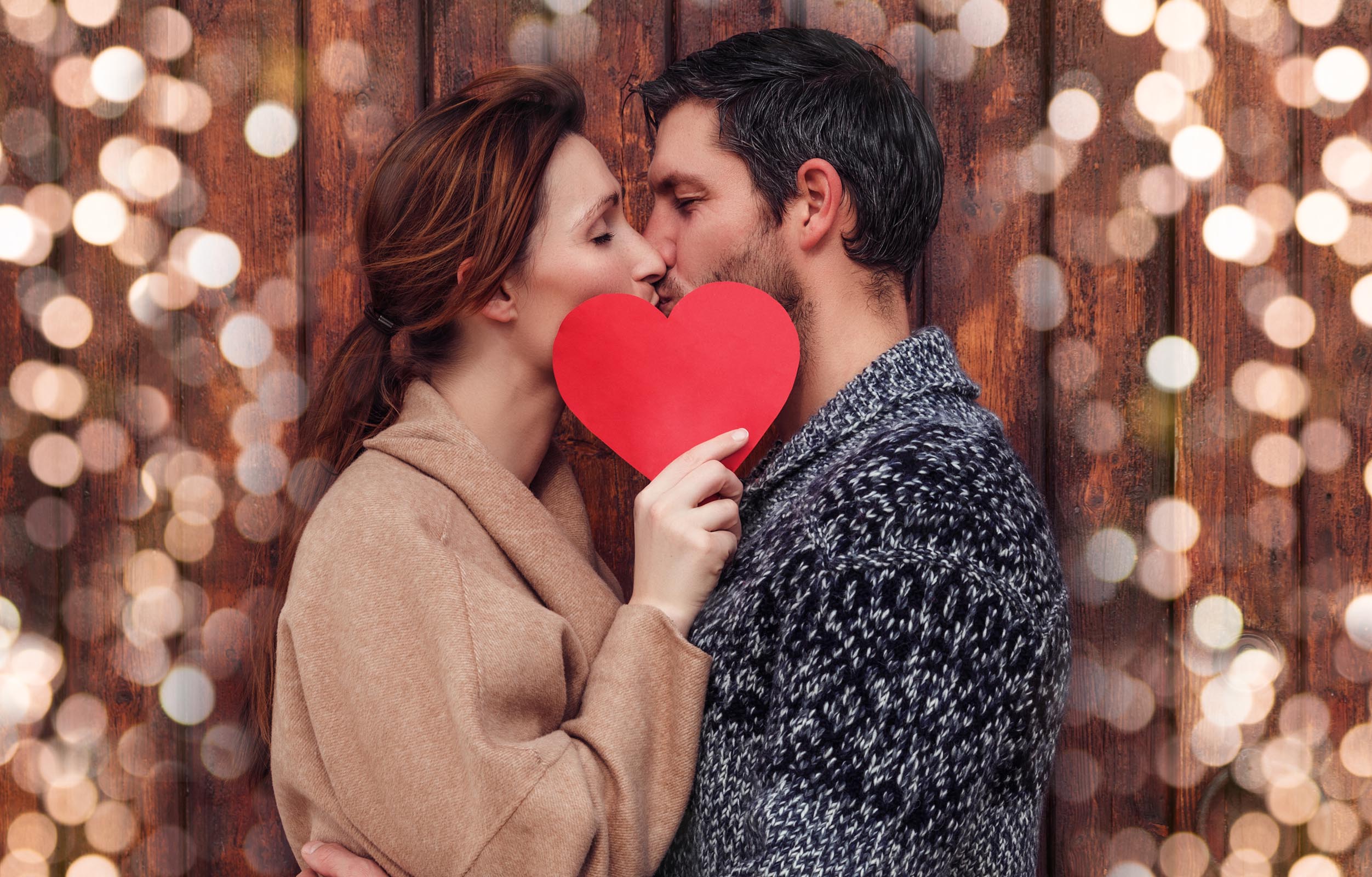 Man and woman kissing behind heart